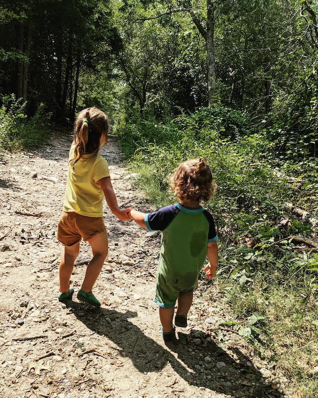 two children walking on a dirt path