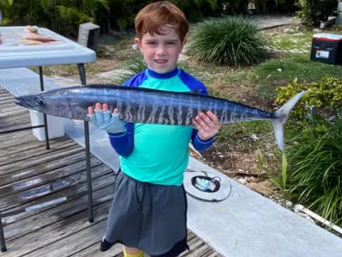 a boy holding a fish