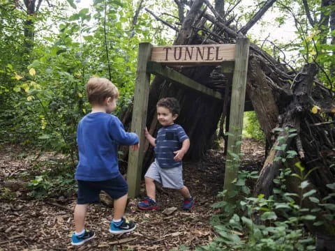 two boys standing next to a sign