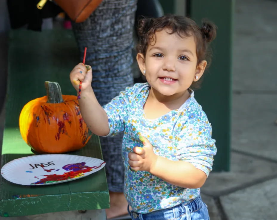 a girl holding a pumpkin