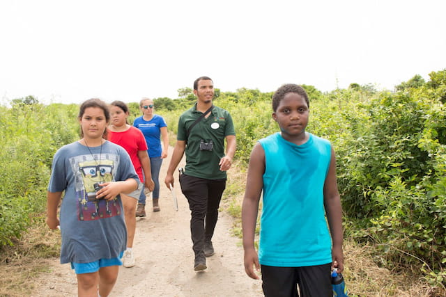 a group of people walking on a dirt path