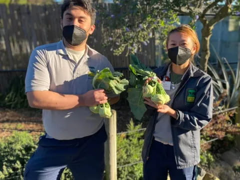 a man and a woman holding plants