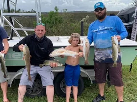 a group of people holding fish