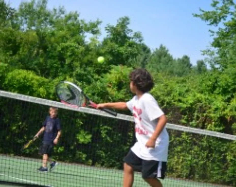a couple of kids playing tennis