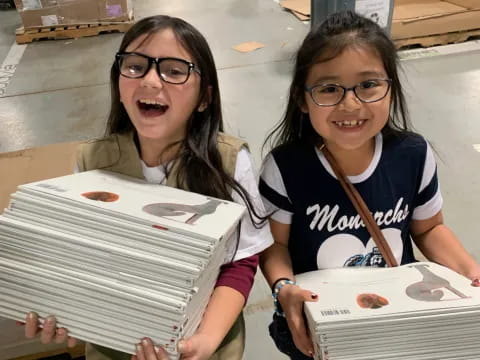 a couple of girls holding boxes