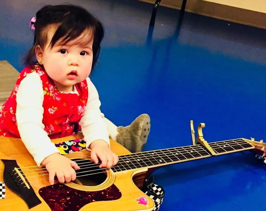a baby playing a guitar
