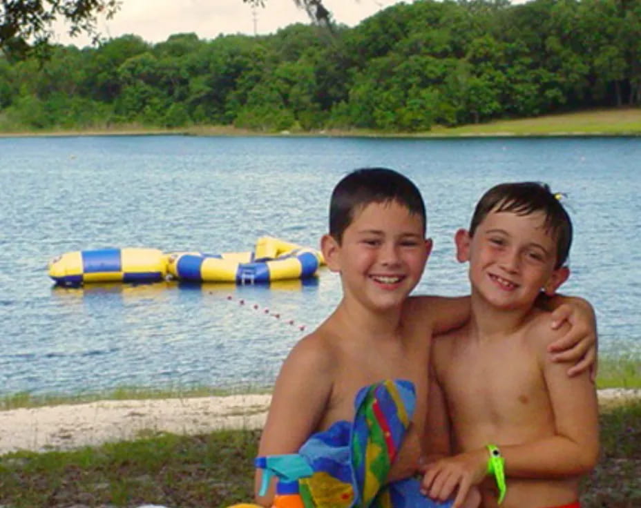 two boys sitting on a dock