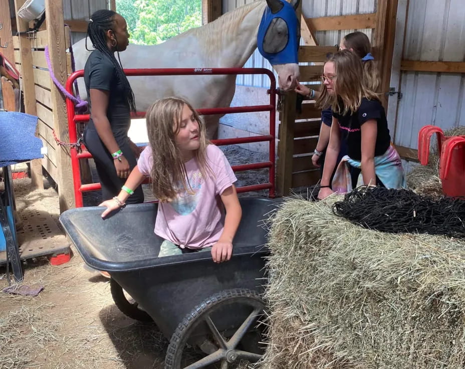 a girl in a wagon with hay