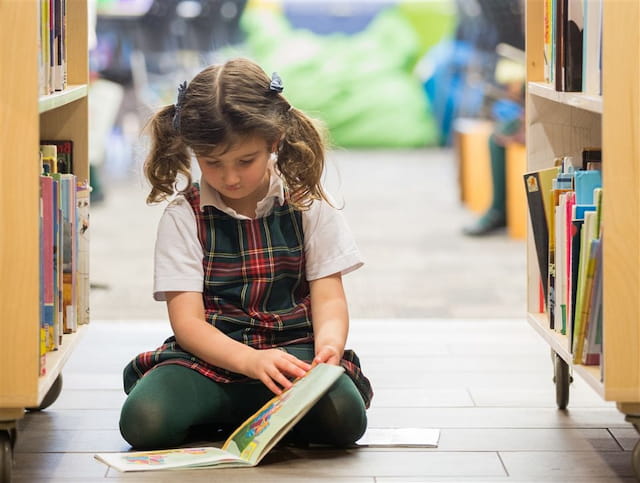 a young girl reading a book
