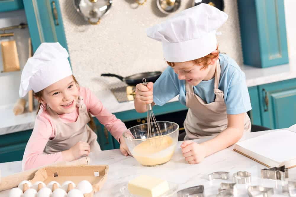 a couple of kids wearing chef hats