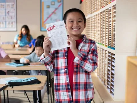 a boy holding a paper