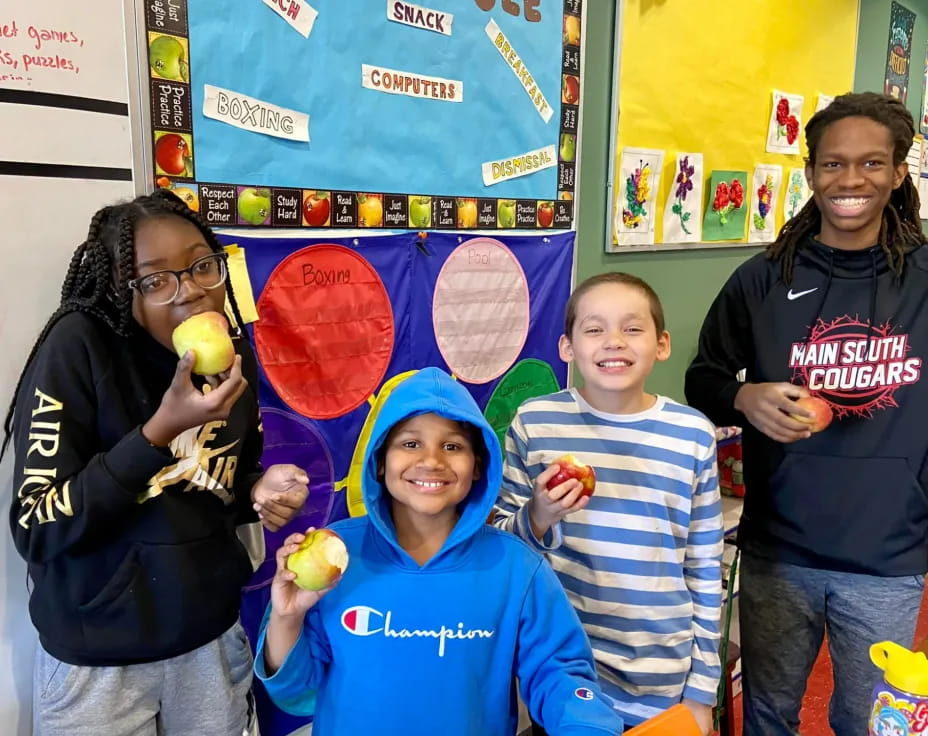 a group of people holding fruit