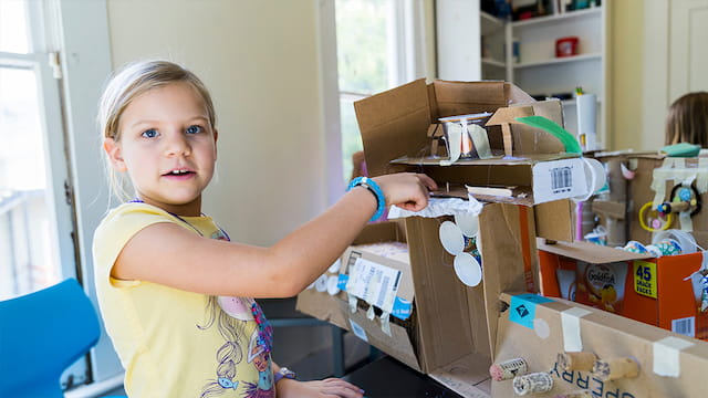 a girl holding a box of cookies