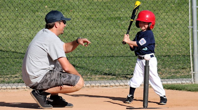a person and a boy playing baseball