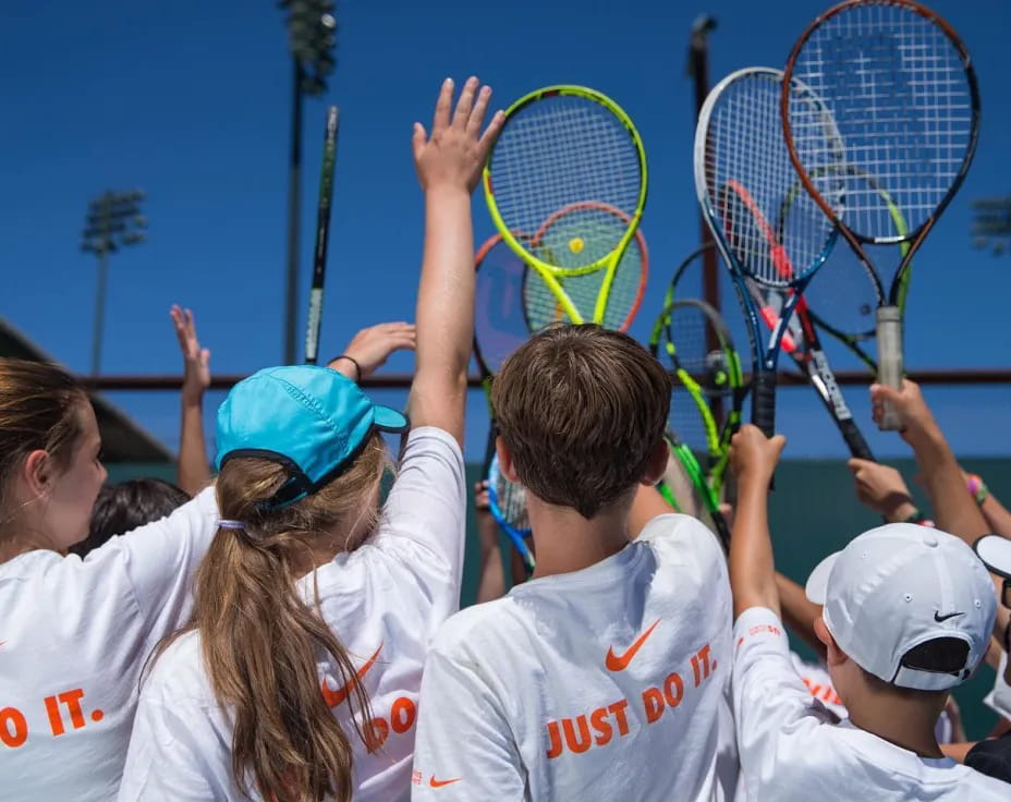 a group of kids playing tennis