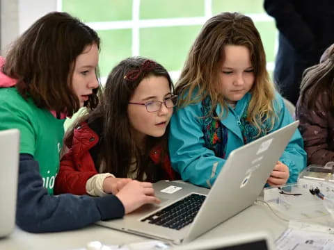 a group of girls using laptops