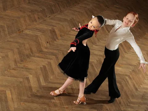 two women dancing on a wood floor