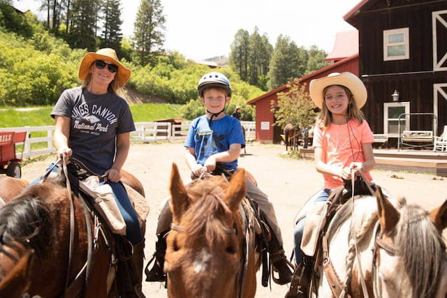 a group of people ride horses
