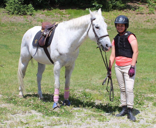 a person standing next to a white horse