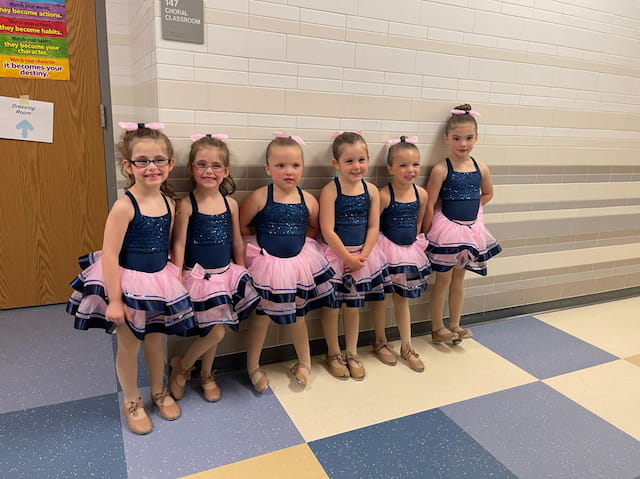 a group of girls in matching outfits