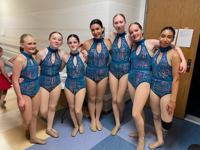 a group of women in blue dresses