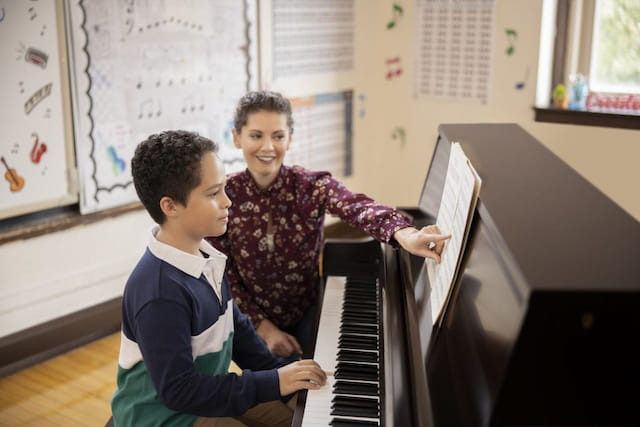 a person and a boy playing piano