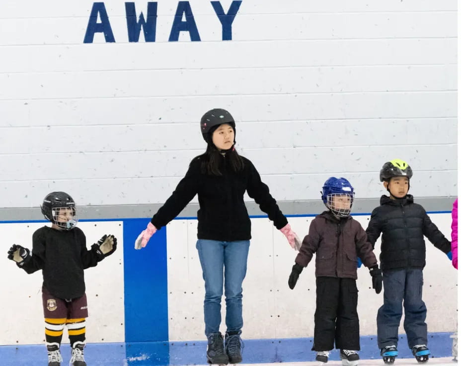 a man and several kids on ice