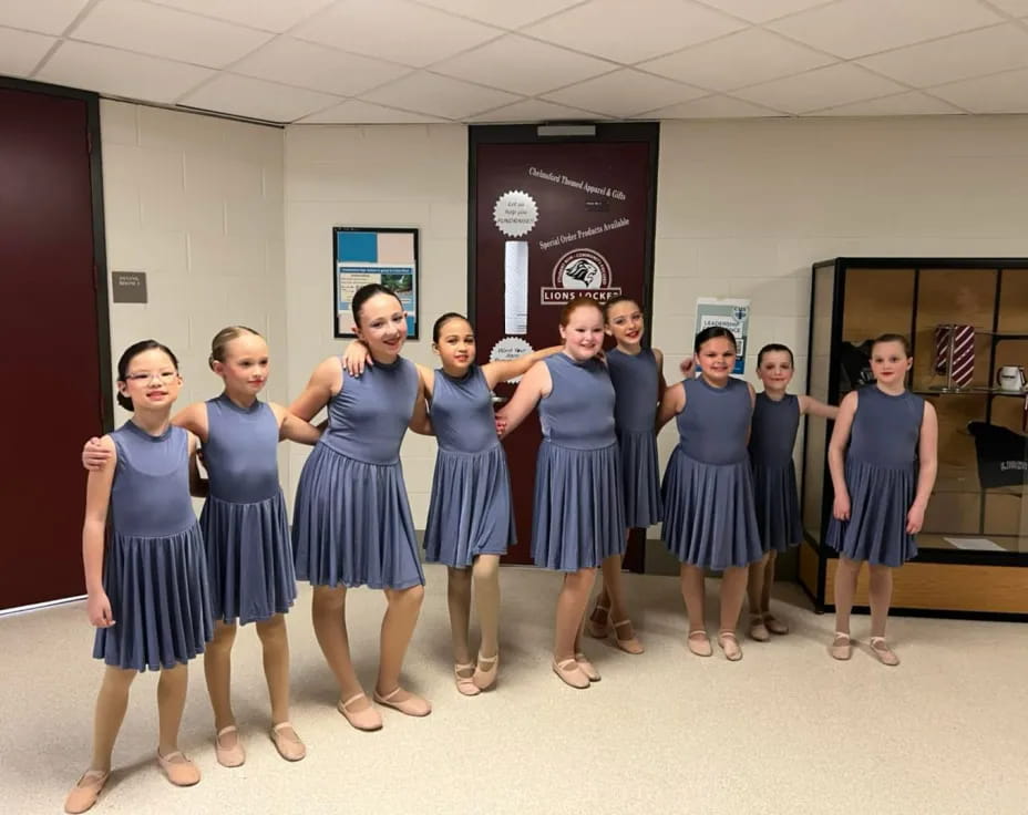 a group of girls in blue dresses