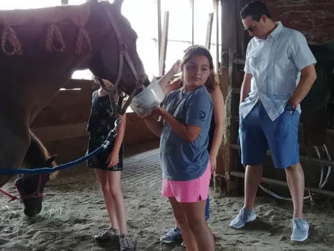a girl standing next to a horse