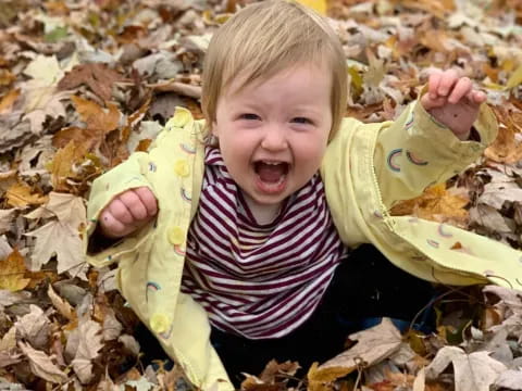 a baby lying in leaves