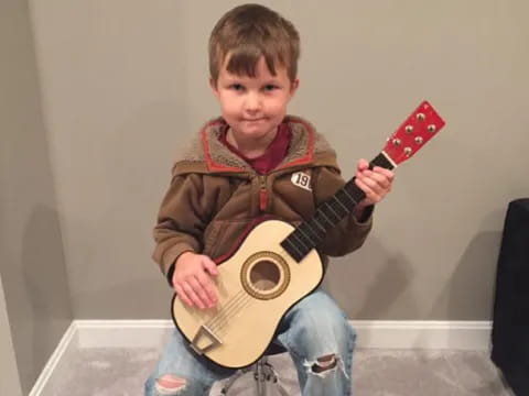 a boy holding a guitar