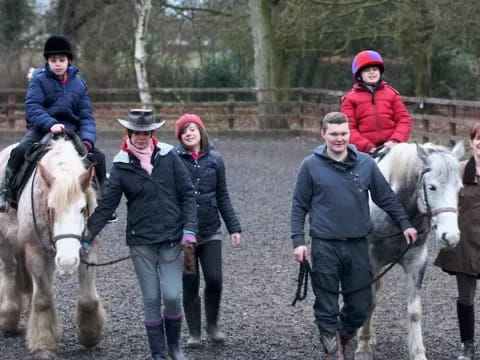 a group of people walking horses