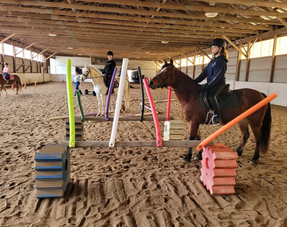 a person riding a horse in a stable