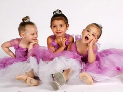 a group of girls in pink dresses