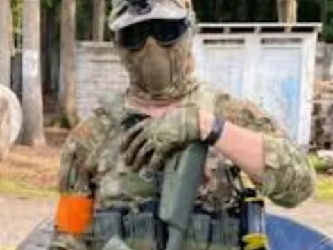 a man in a garment holding a gun