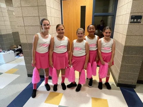 a group of women in pink outfits