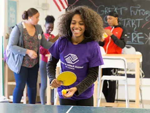 a young girl holding a ball