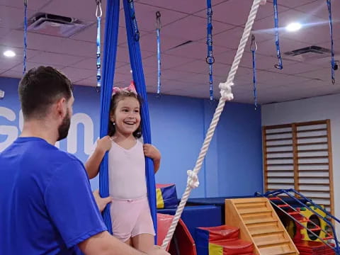 a man and a girl on a swing set