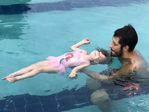 a person and a baby in a pool