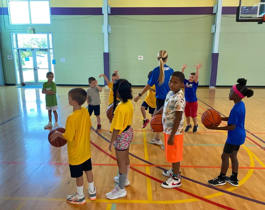 a group of kids playing basketball
