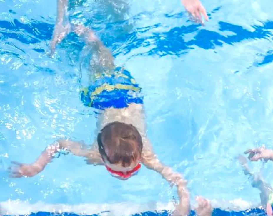 a boy swimming in a pool