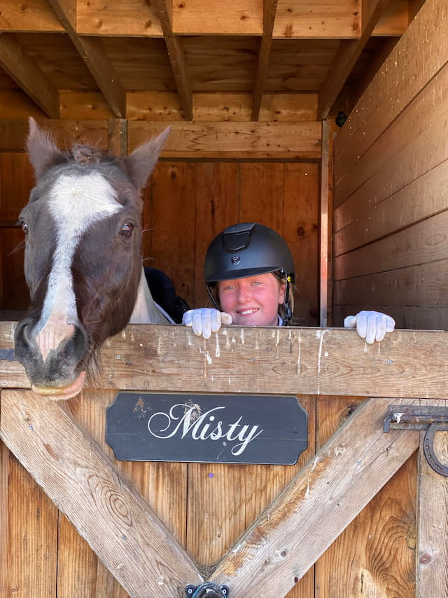 a person and a horse in a stable