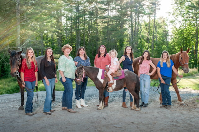a group of people posing with horses