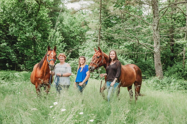 a group of people standing next to some horses