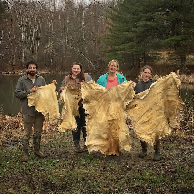 a group of people holding large bales of hay