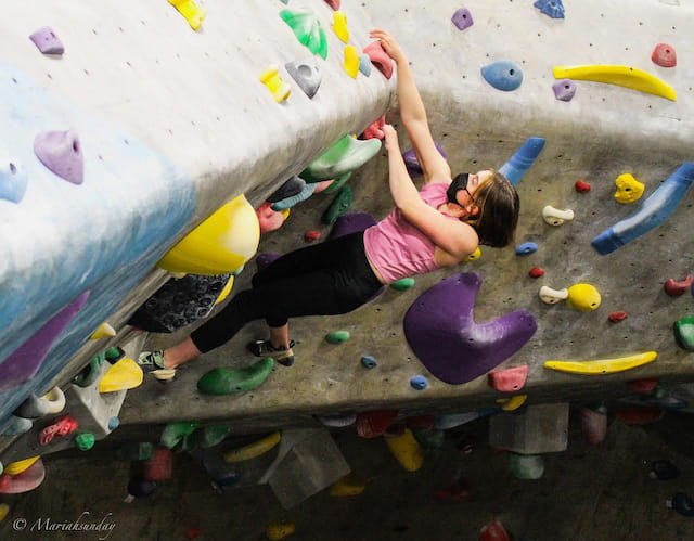 a girl climbing a rock wall