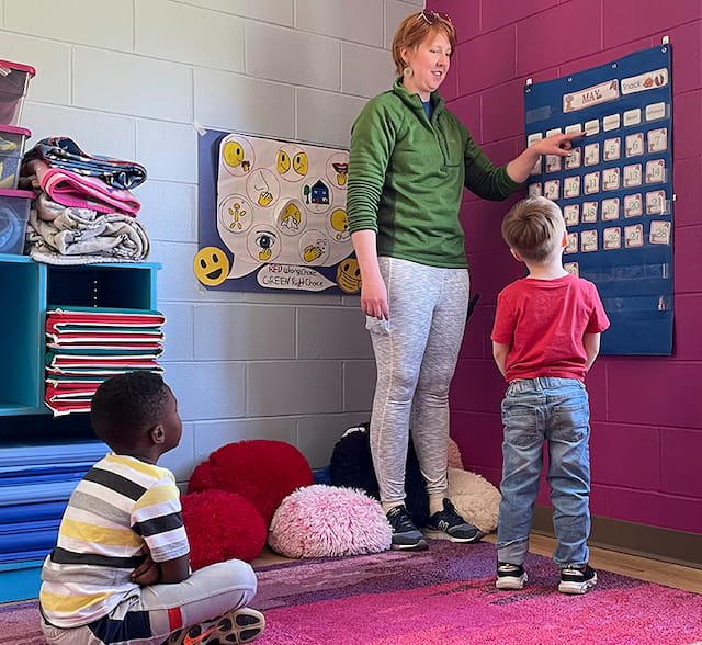 a person and two children in a classroom