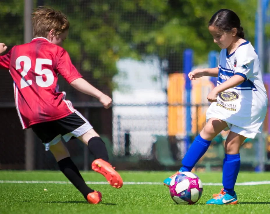 girls playing football on a field