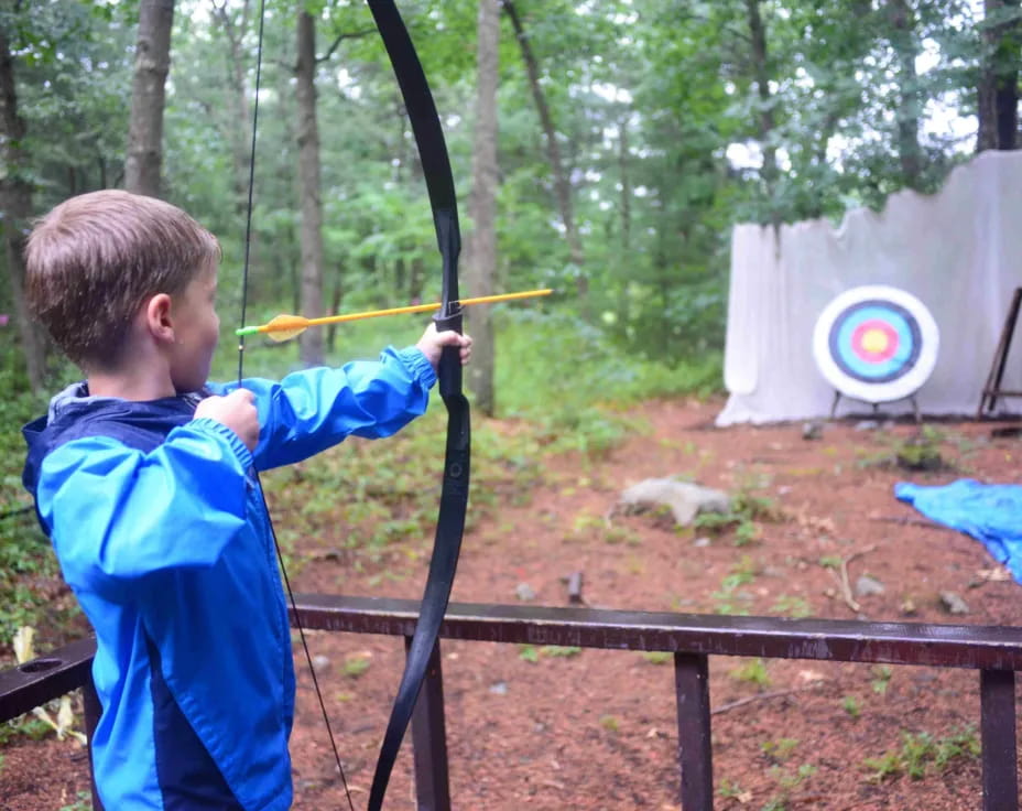 a boy shooting a bow and arrow