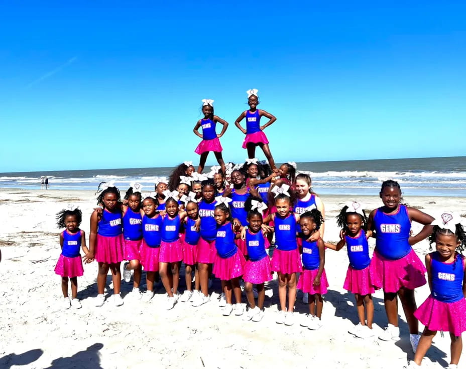 a group of girls posing on a beach